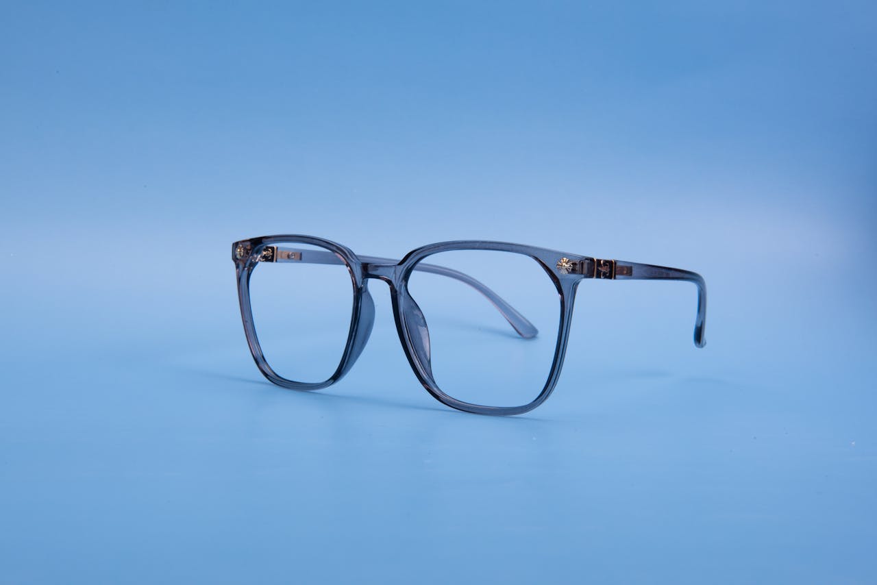 Classic eyeglasses on a blue background with minimalistic style.
