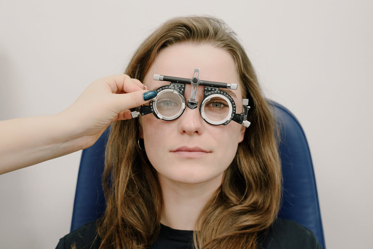 Close-up of an eye exam with a phoropter by a female ophthalmologist.